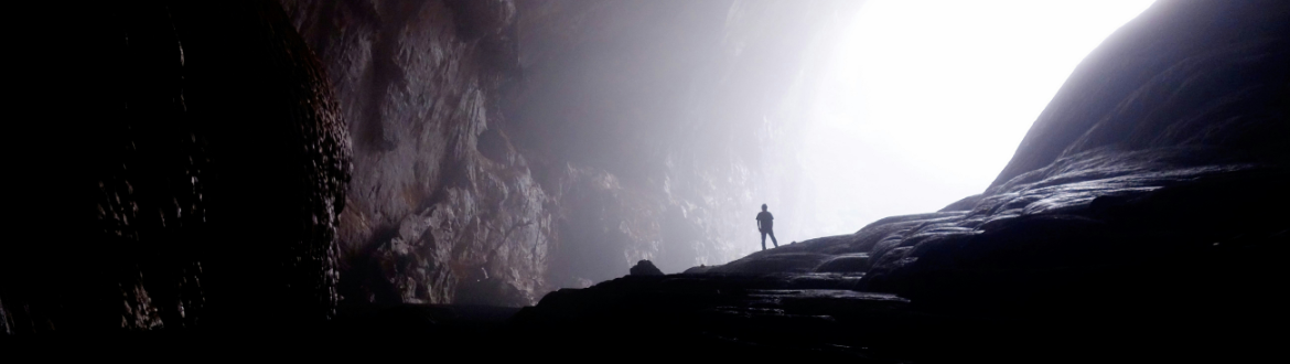 man standing in dark valley