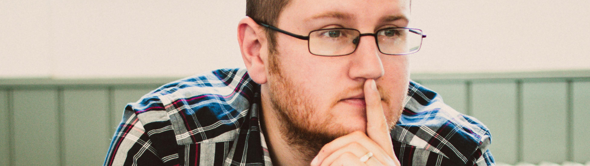 Man wearing glasses looking pensive