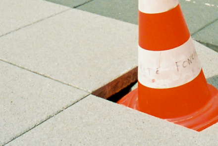 Cone in damaged paving slab